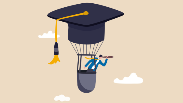 Man looking through a telescope in a hot air balloon shaped like a graduation cap