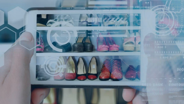 hand holding tablet screen with image of shoes in closet. 