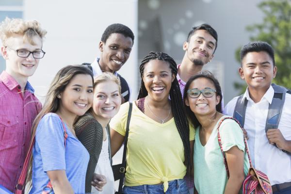 Group of happy high school students smiling at the camera.