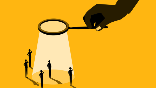 Magnifying glass shining down on five figures. 