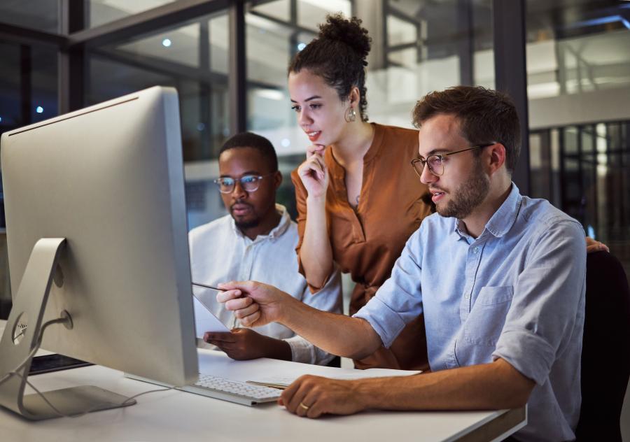 Three colleagues having discussion in front of a computer 